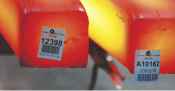 High-temperature-resistant barcode labels applied to glowing hot metal billets in an industrial setting.